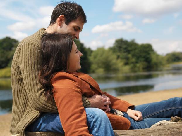 Young couple sitting near lake