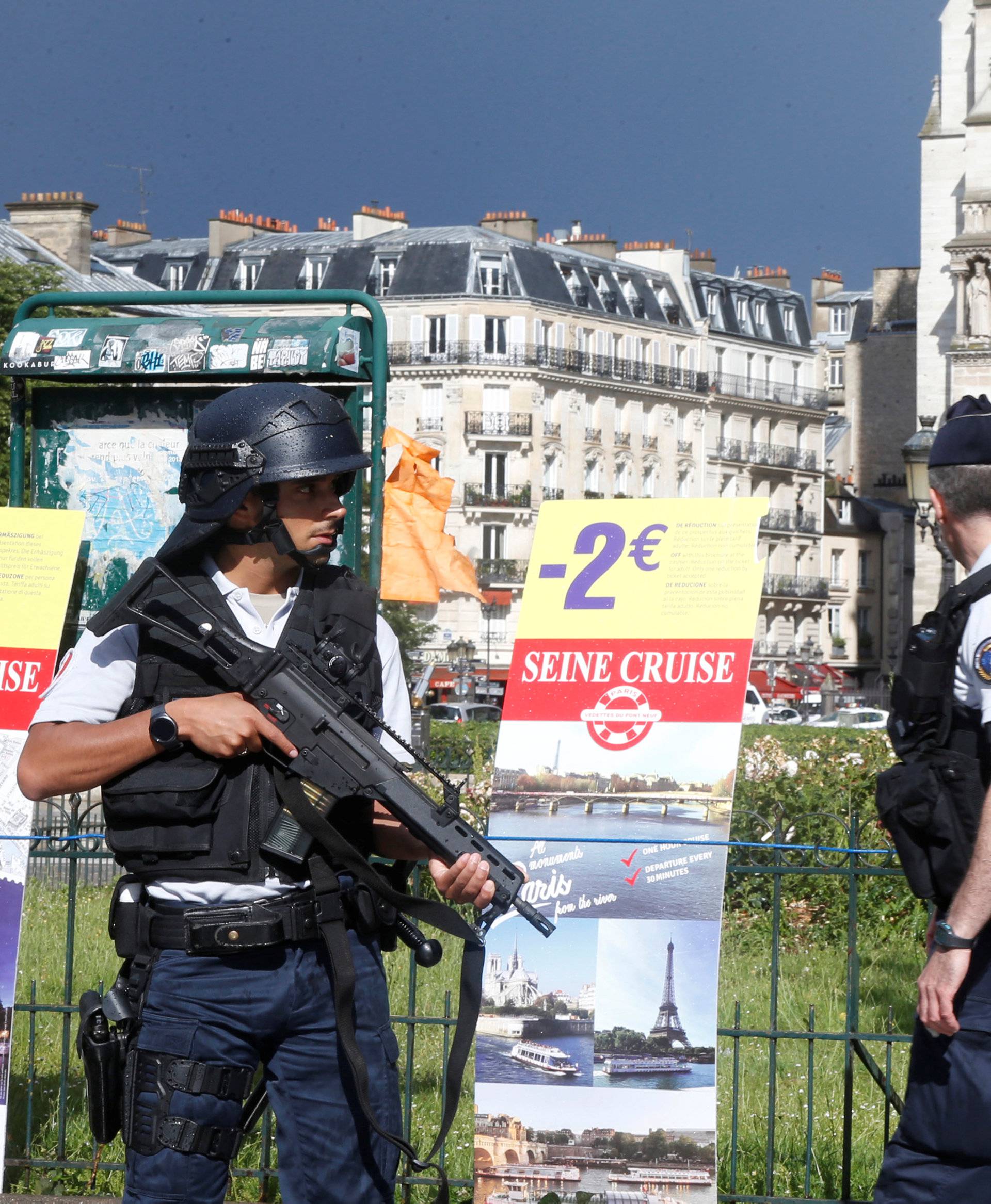 French police stand at the scene of a shooting incident near the Notre Dame Cathedral in Paris