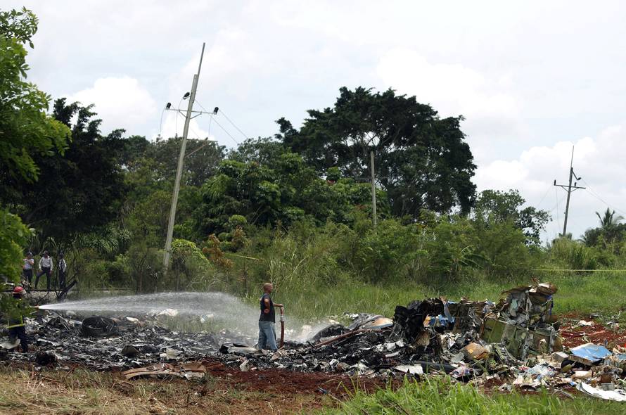 Rescue team members work in the wreckage of a Boeing 737 plane that crashed in the agricultural area of Boyeros