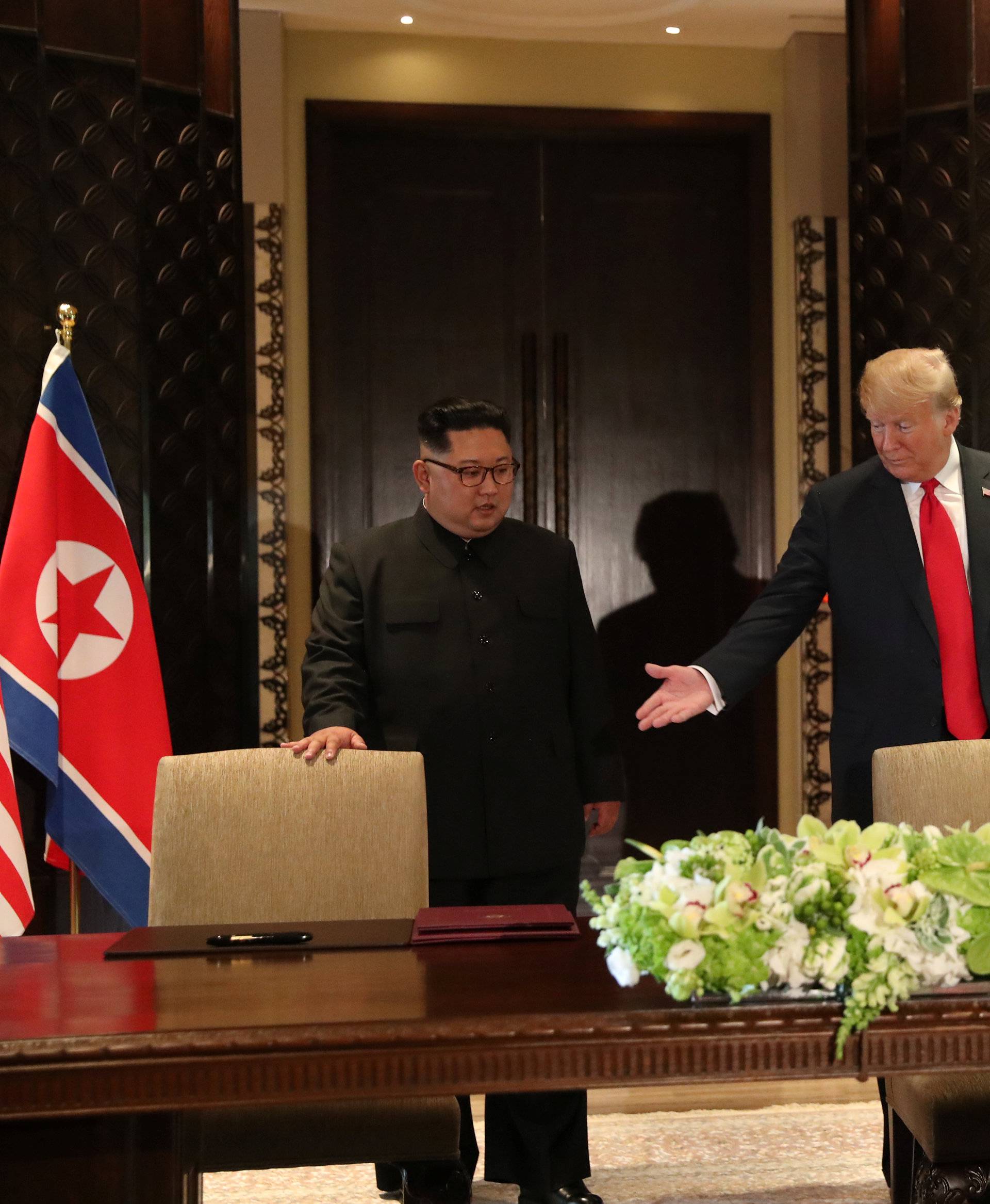 U.S. President Donald Trump and North Korea's leader Kim Jong Un arrive to sign a document, after their summit in Singapore
