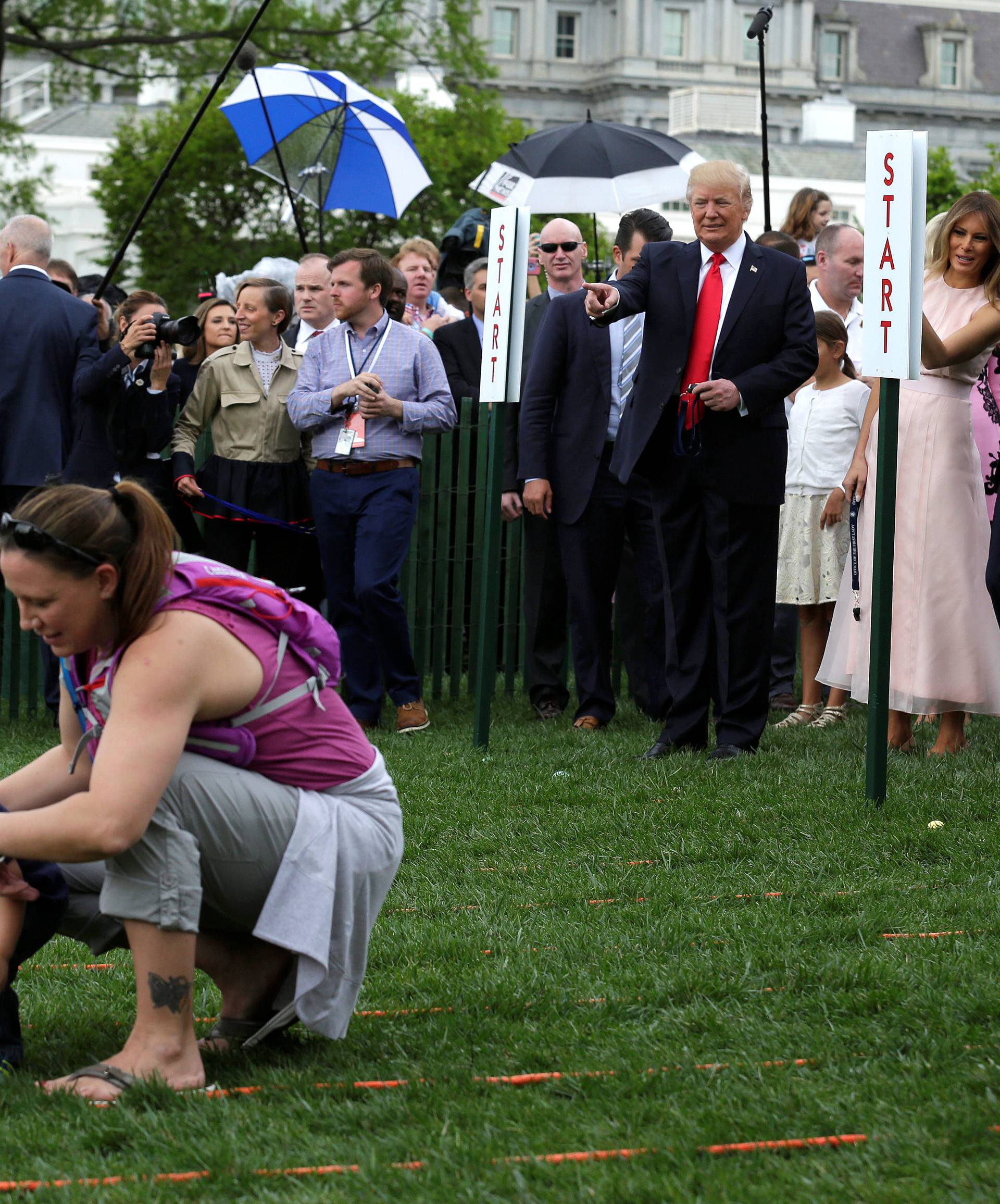 U.S. President Donald Trump, U.S. first lady Melania Trump and their son Barron watch as parents help their children during the 139th annual White House Easter Egg Roll on the South Lawn of the White House in Washington