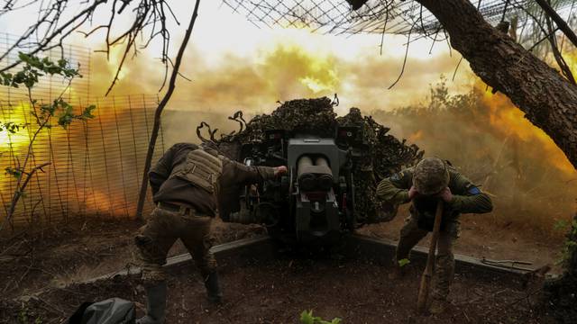 Ukrainian serviceman fire a D-30 howitzer towards Russian troops at a position in a front line near the town of Soledar
