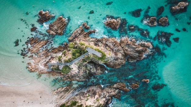 Aerial view of rock formations and crashing waves in the sea