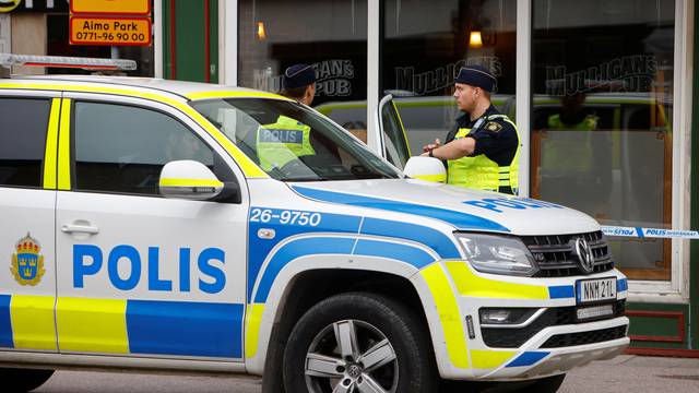 Police officers secure the area outside of a restaurant following a shooting in Sandviken