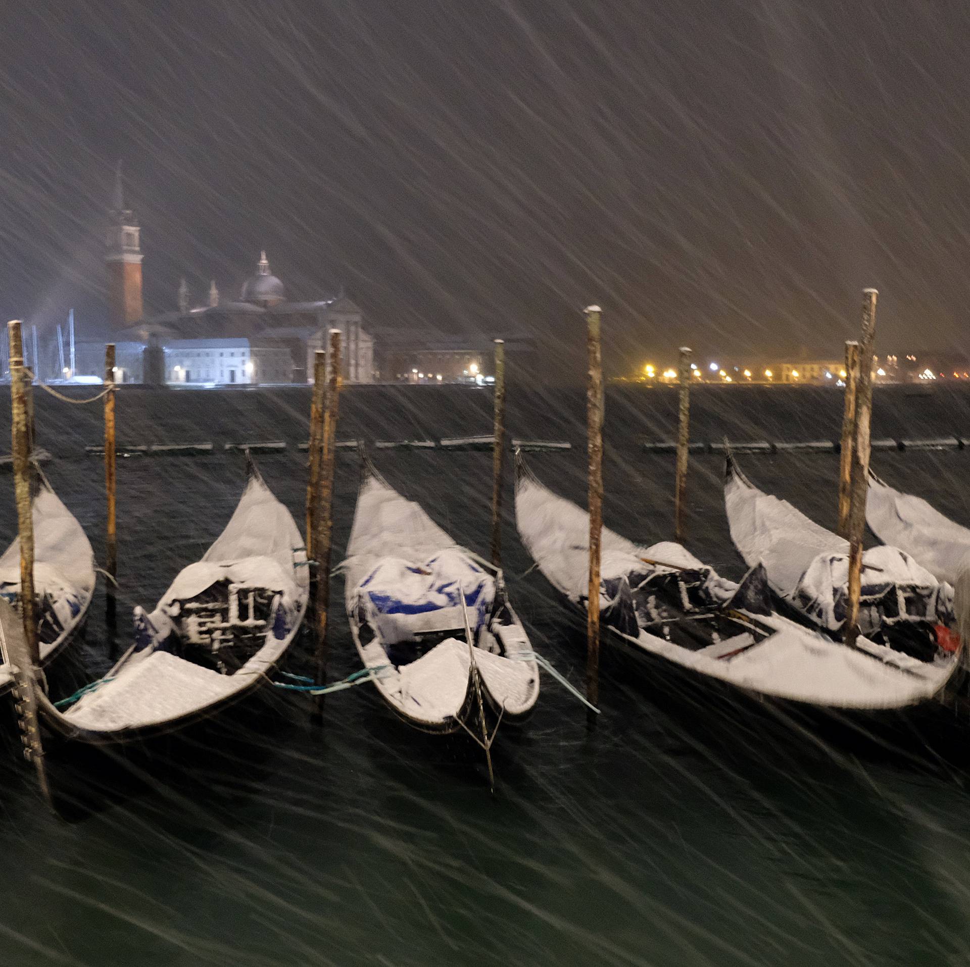 Gondolas are seen during snowfall in the Venice lagoon