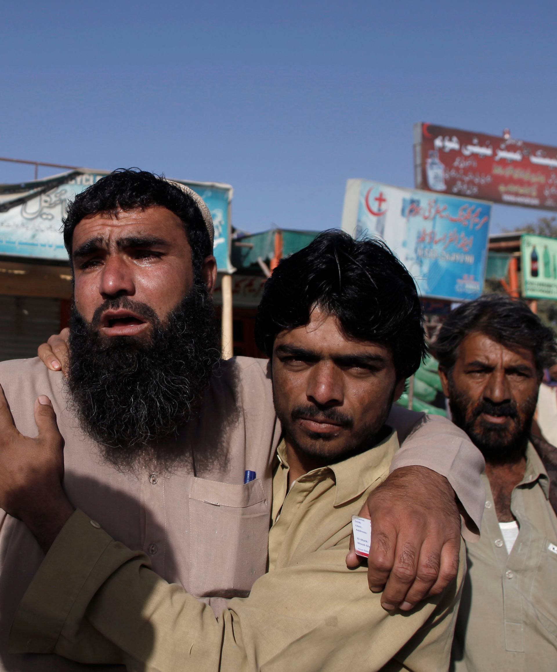 Relatives of police cadets wait for word outside the Police Training Center after an attack on the center in Quetta