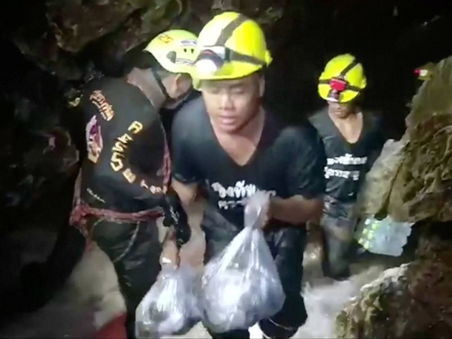 Rescuers carry supplies into the Tham Luang cave complex, where 12 boys and their soccer coach are trapped, in the northern province of Chiang Rai