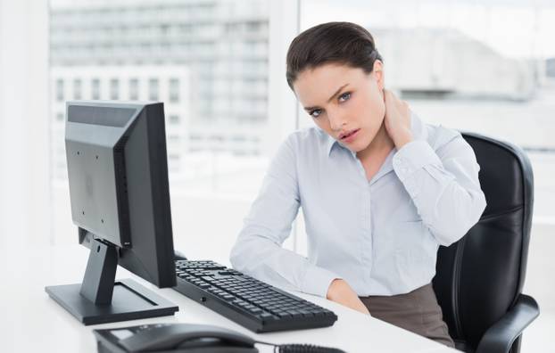 Businesswoman with neck pain sitting at office