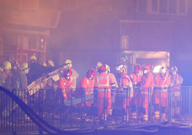 Members of the emergency services move debris at the site of an explosion which destroyed a convenience store and a home in Leicester