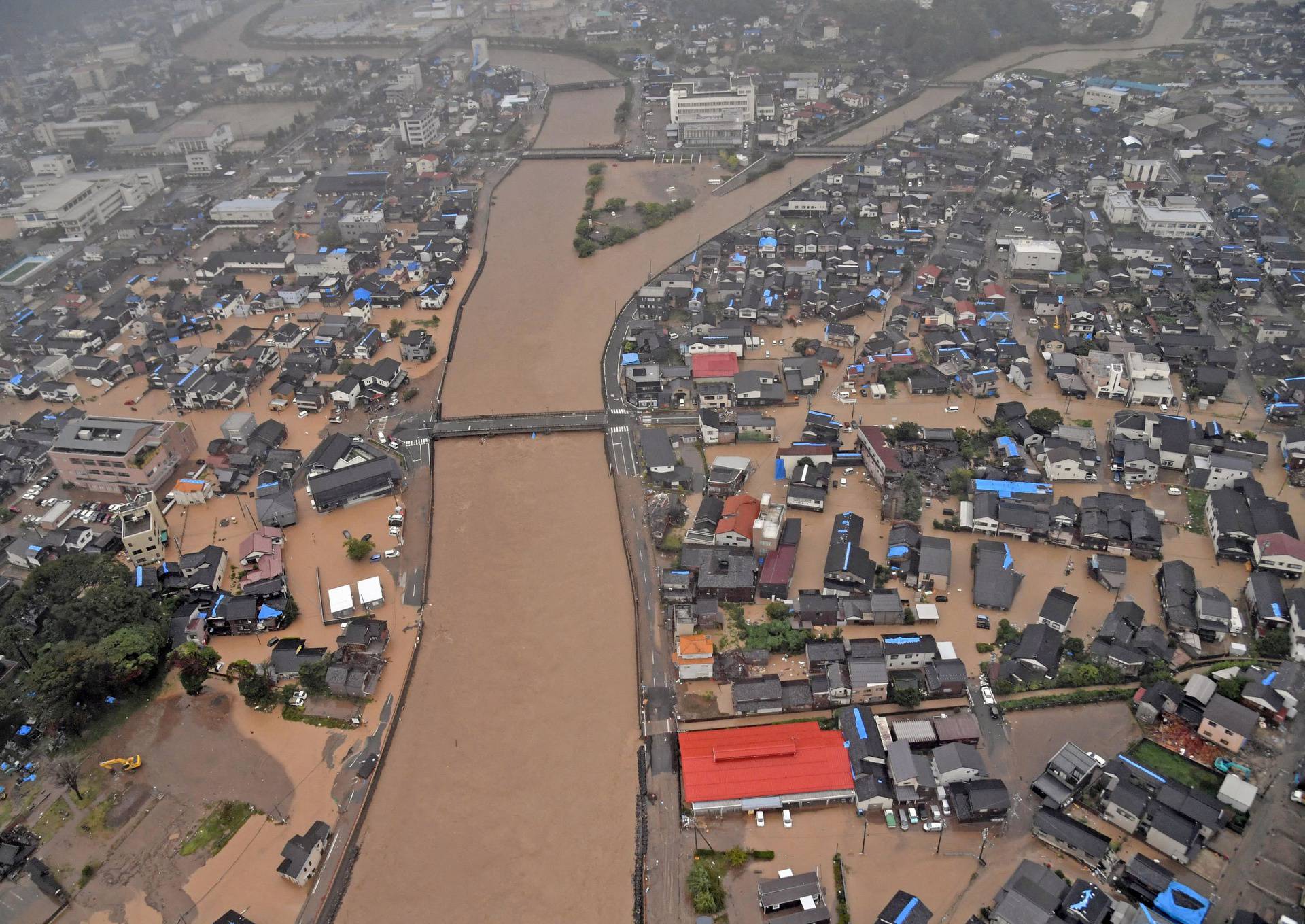 An aerial view taken by a helicopter shows flooded residential area caused by a torrential rain in Wajima