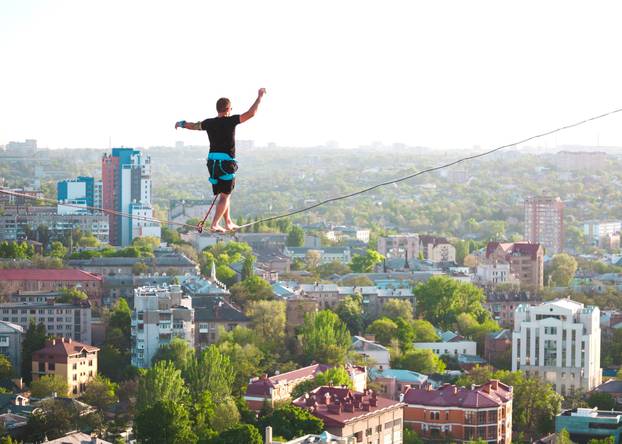 The man is balancing over the city.