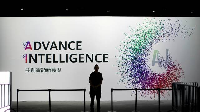 FILE PHOTO: A security officer keeps watch in front of an AI (Artificial Intelligence) sign at the annual Huawei Connect event in Shanghai