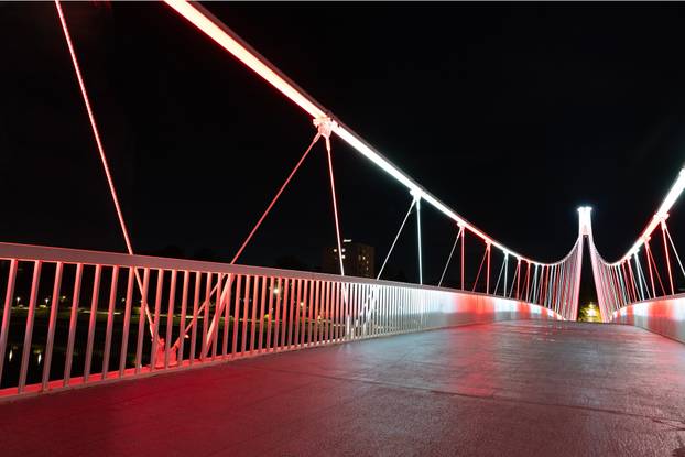 Osijek: Pješački most osvijetljen crveno bijelom  bojom povodom Dana sjećanja na žrtvu Vukovara i Škabrnje