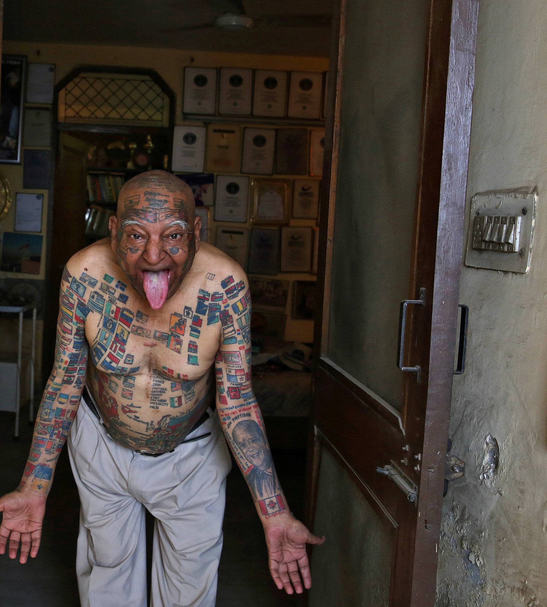 Guinness Rishi, multiple world record holder including most flags tattooed on his body, poses for a photograph outside his apartment in New Delhi