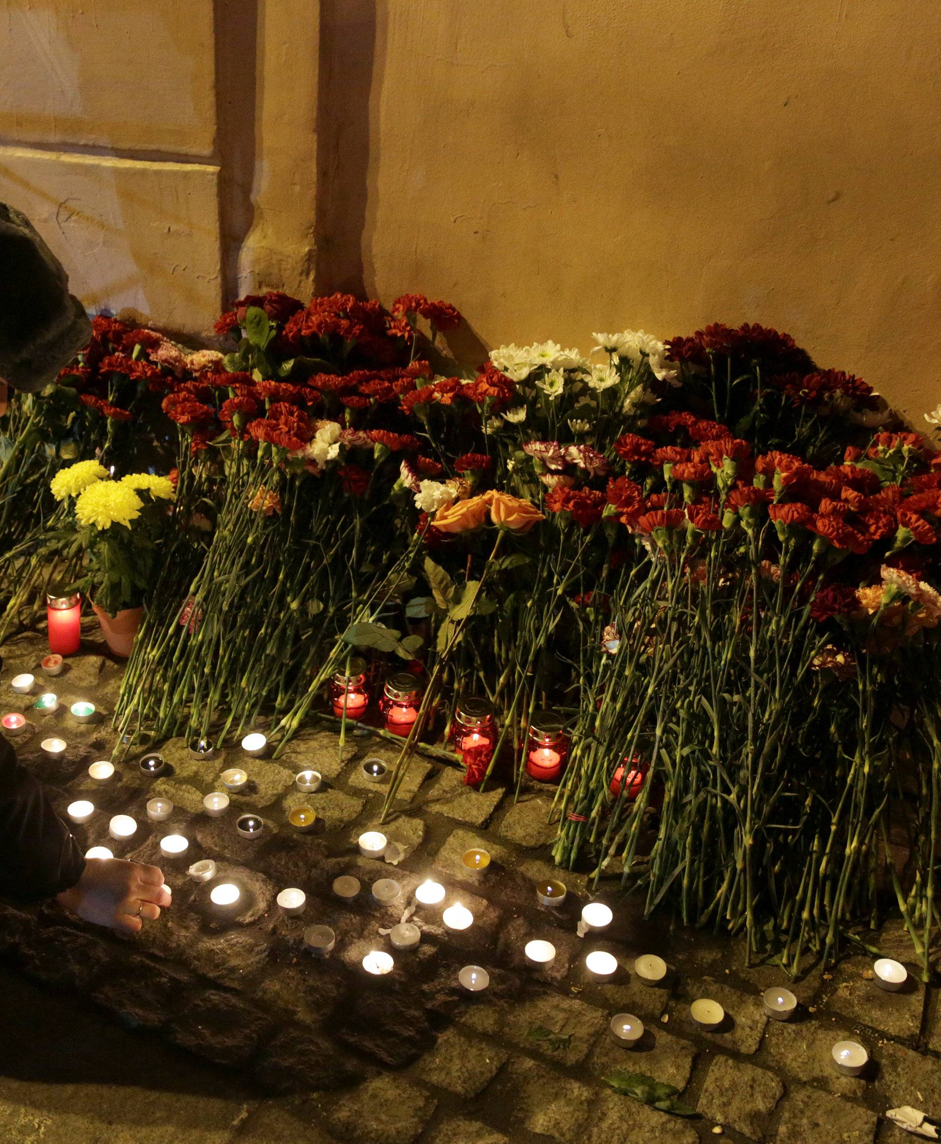 A police officer leaves a candle during a memorial service for victims of a blast in St. Petersburg metro, outside Tekhnologicheskiy institut metro station in St. Petersburg