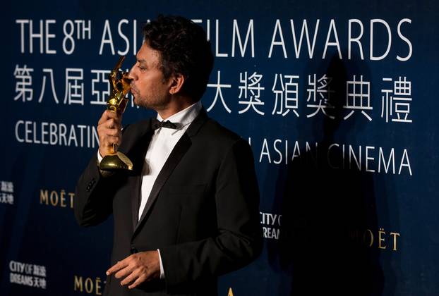 FILE PHOTO: Khan kisses his trophy after winning the Best Actor for "The Lunchbox" at the 8th Asian Film Awards in Macau