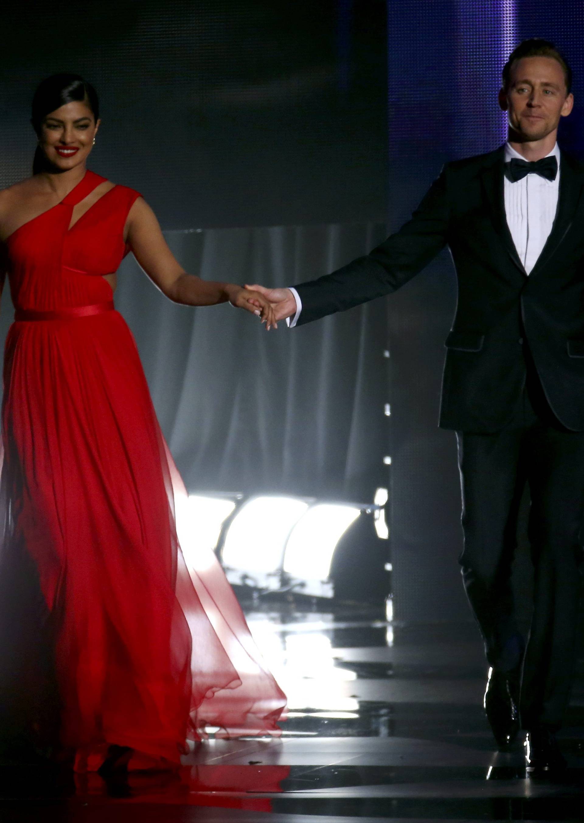 Actors Chopra and Hiddleston walk onstage to present an award at the 68th Primetime Emmy Awards in Los Angeles