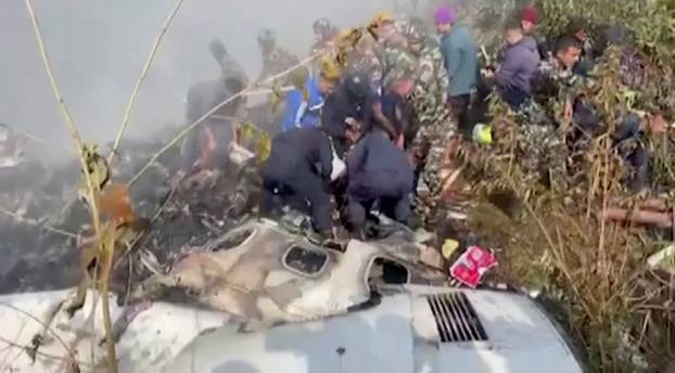 Rescuers work at the site of a plane crash in Pokhara