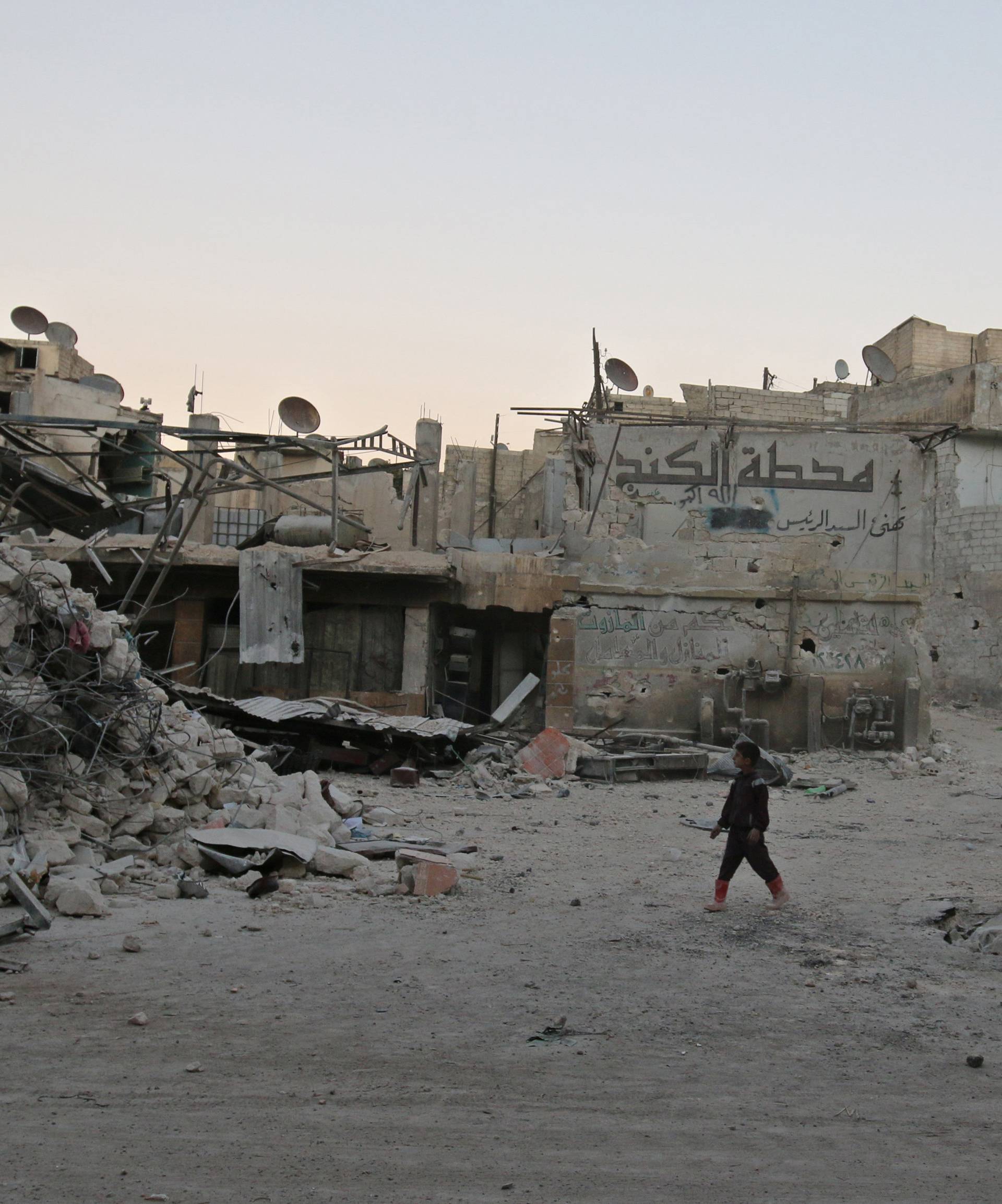 A boy walks amid damaged buildings in the rebel held area of al-Kalaseh neighbourhood of Aleppo