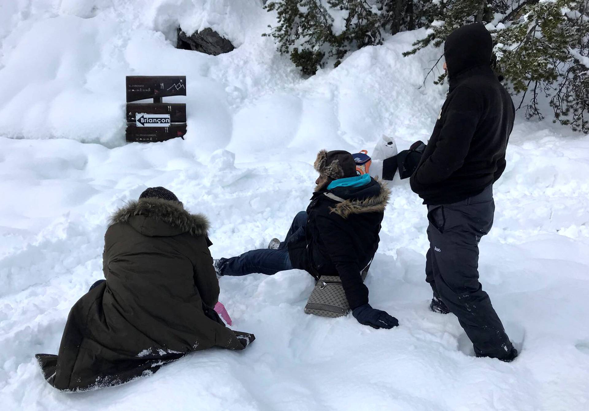 Migrants take rests in the snow after failing to cross from Italy to France due to heavy snow fall, in Bardonecchia