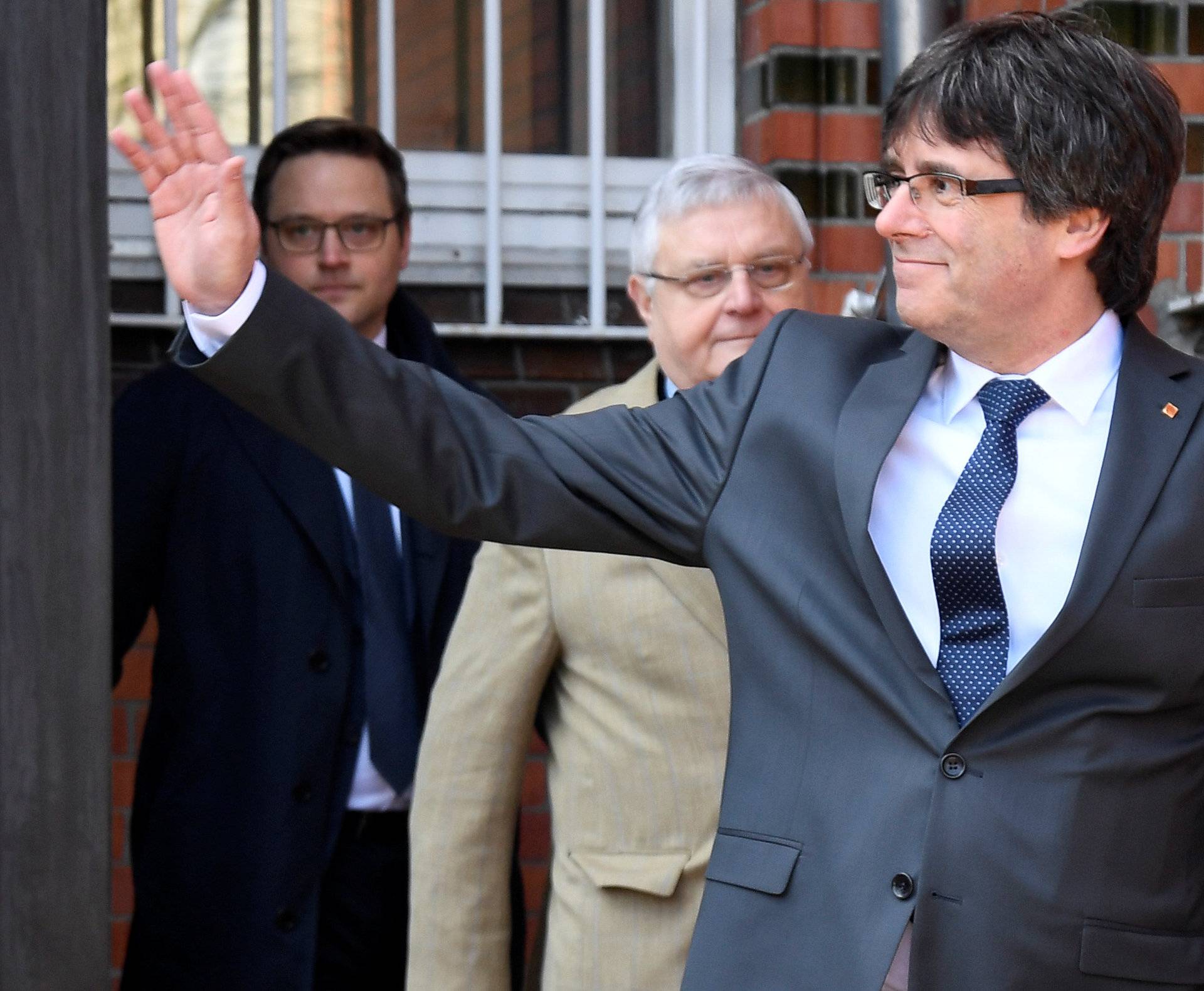 Catalonia's former leader Carles Puigdemont waves as he leaves the prison in Neumuenster