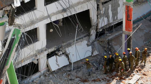 Israeli rescue services search through the rubble after a building site collapsed in Tel Aviv