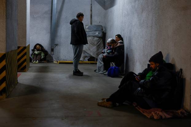 People take shelter inside an underground parking lot during a Russian missile and drone attack in Kyiv
