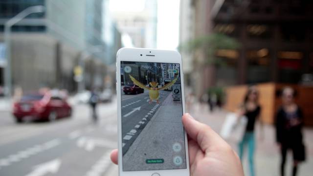 Photo illustration of a "Pidgey" Pokemon seen on the screen of the Pokemon Go mobile app 