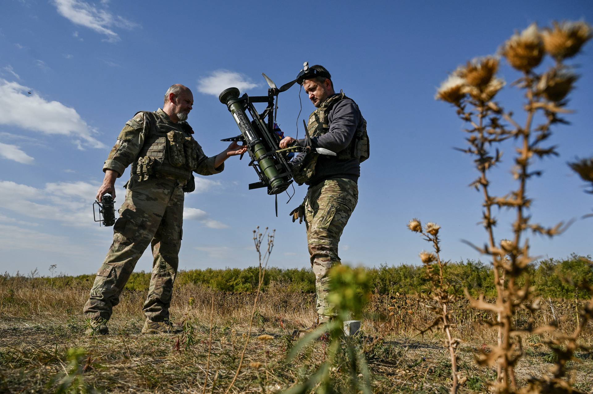 Ukrainian servicemen prepare for a test fly an FPV drone with an attached portable grenade launcher at their position near a frontline in the Zaporizhzhia region