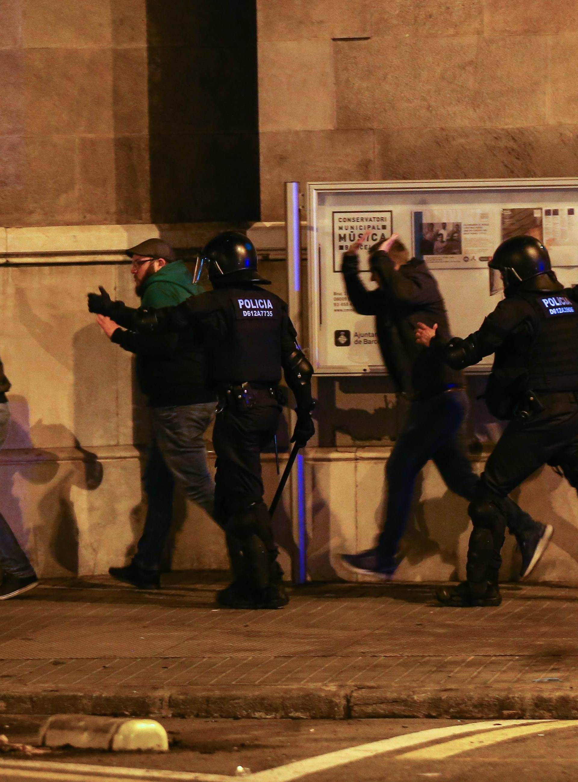 Protestors are dispersed by Catalan police during skirmishes after former regional president Carles Puigdemont was detained in Germany,  in Barcelona