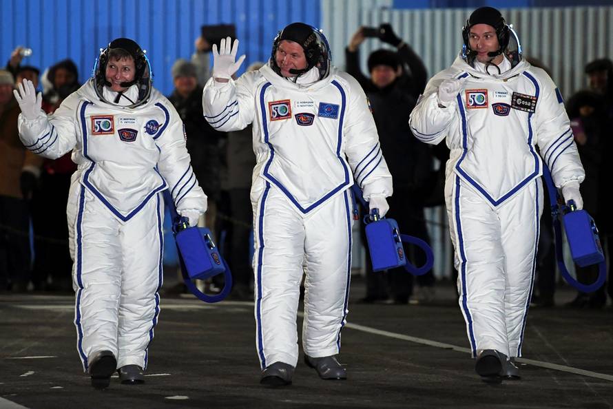 The International Space Station (ISS) crew members Peggy Whitson of the U.S., Oleg Novitskiy of Russia and Thomas Pesquet of France walk to board the Soyuz MS-03 spacecraft for the launch at the Baikonur cosmodrome