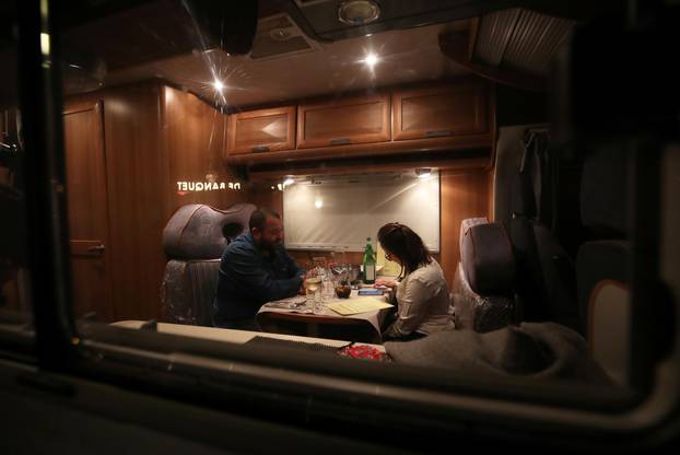 Customers enjoy dinner sitting inside a motorhome camper parked at the Belgian restaurant Matthias And Sea, despite the COVID-19 pandemic lockdown in Tarcienne