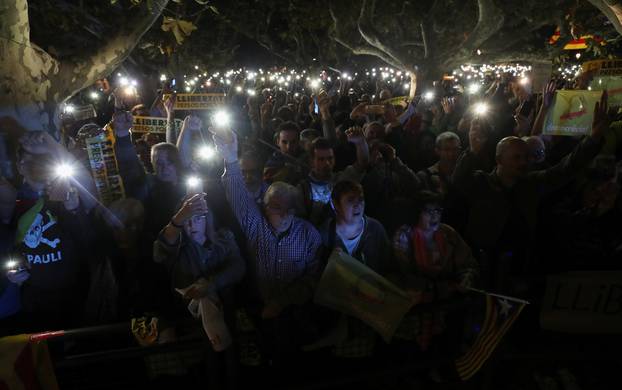 People hold their mobile phones during a gathering in support of the members of the dismissed Catalan cabinet after a Spanish judge ordered the former Catalan leaders to be remanded in cust