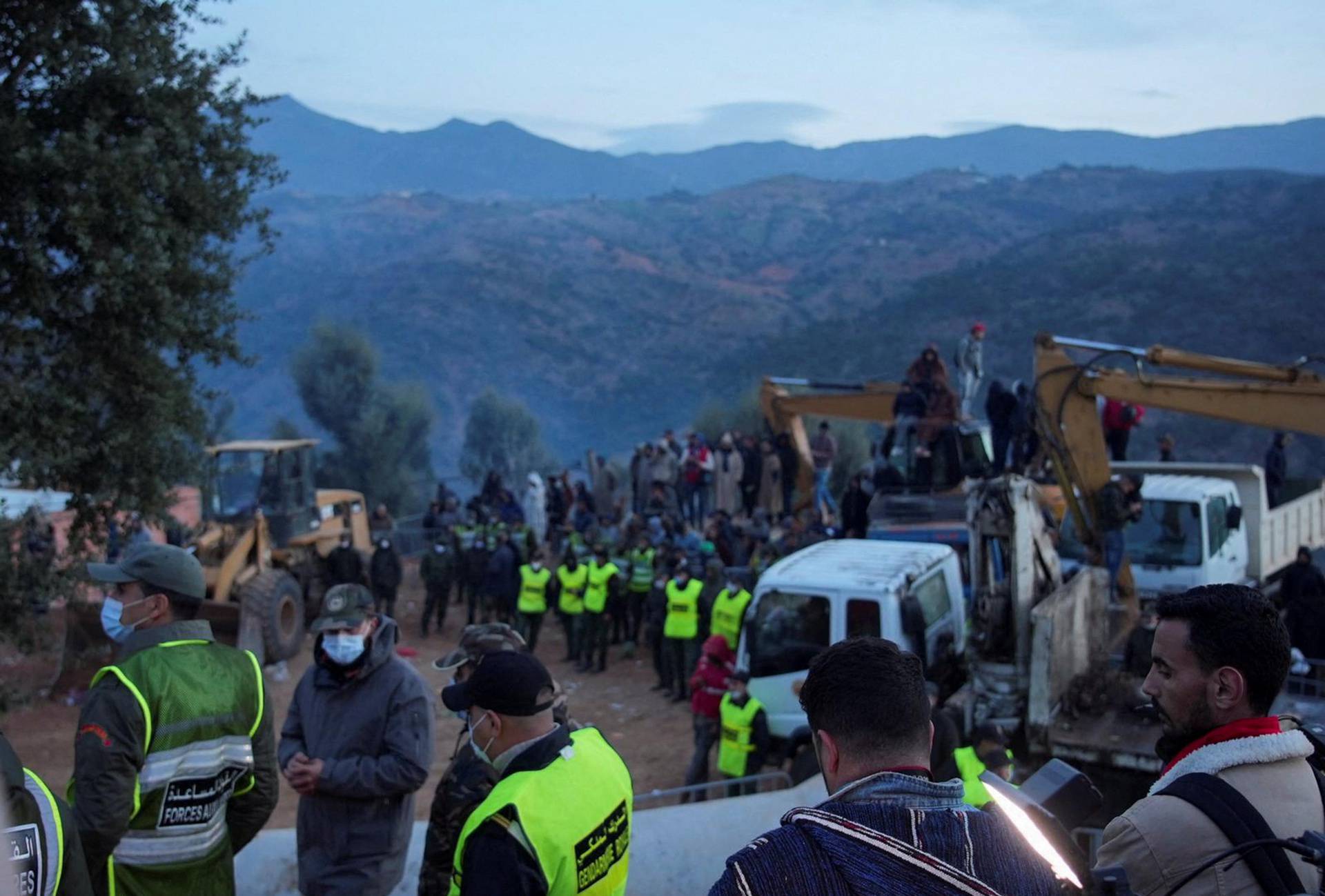 People gather as rescuers work to reach a five-year old boy trapped in a well in the northern hill town of Chefchaouen