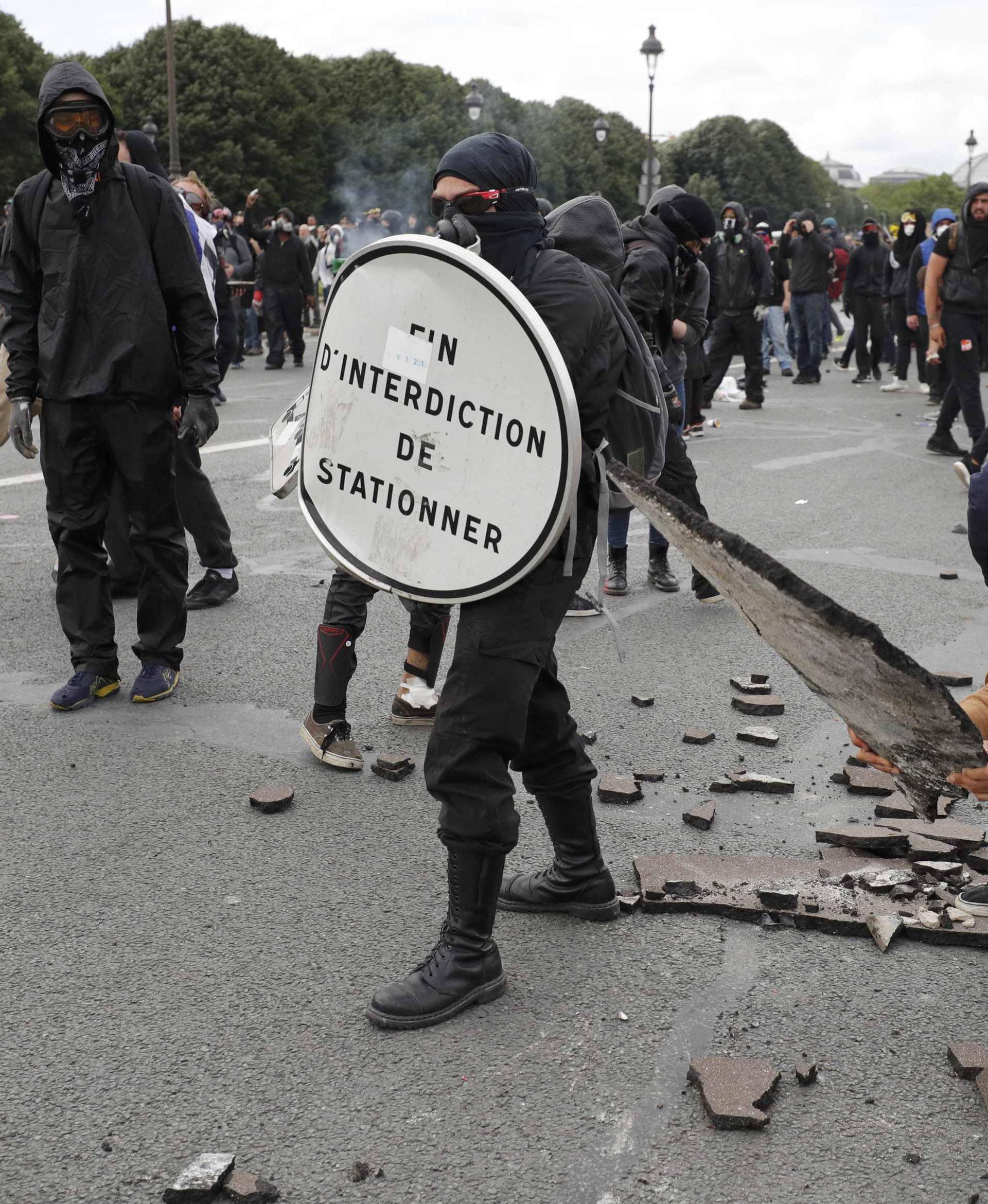 Masked youths face off with French police and gendarmes during clashes at the Invalides square during a demonstration in Paris