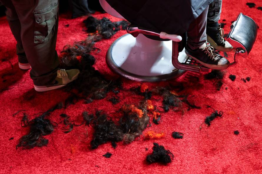 Shaved hair lies on the floor as a fan gets his hair shaved for a free preview of Yorgos Lanthimos’s new film 'Bugonia', in California