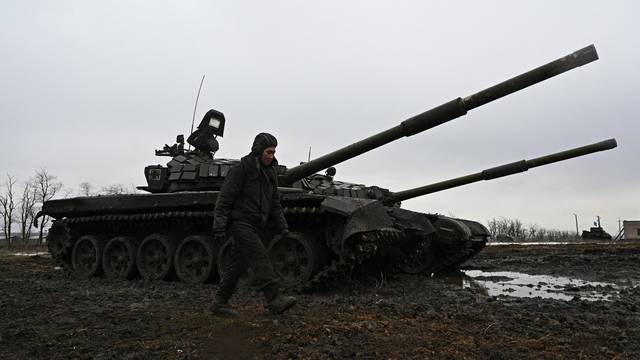 FILE PHOTO: A Russian service member walks past T-72B3 main battle tanks during drills held by the armed forces of the Southern Military District at the Kadamovsky range in the Rostov region, Russia February 3, 2022