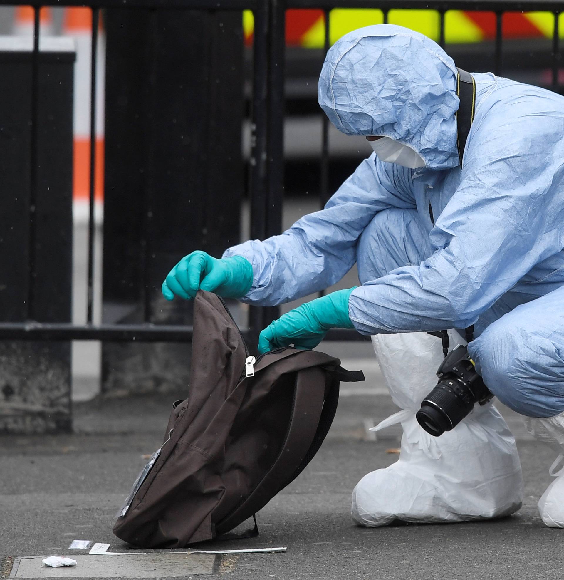 A forensic investigator opens a rucksack after man was arrested on Whitehall in Westminster in central London