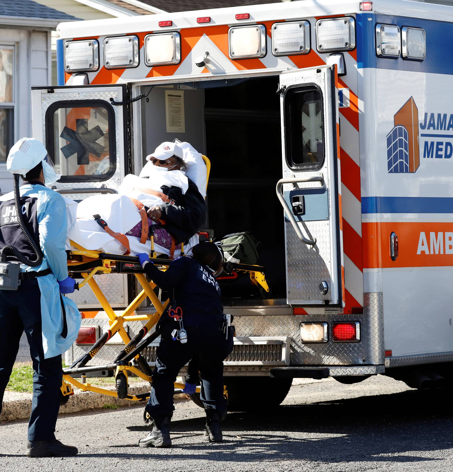 FILE PHOTO: Emergency Medical Technicians (EMT) lift a patient into an ambulance as the the outbreak of coronavirus disease (COVID-19) continues, in New York