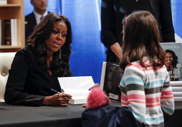 Former first lady Michelle Obama signs copies of her memoir "Becoming" at the Seminary Co-op Bookstore in Chicago