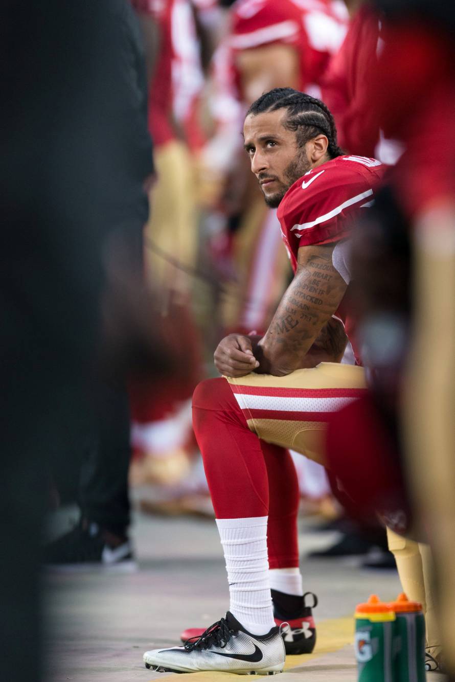 FILE PHOTO: San Francisco 49ers quarterback Colin Kaepernick (7) sits during the national anthem in Santa Clara