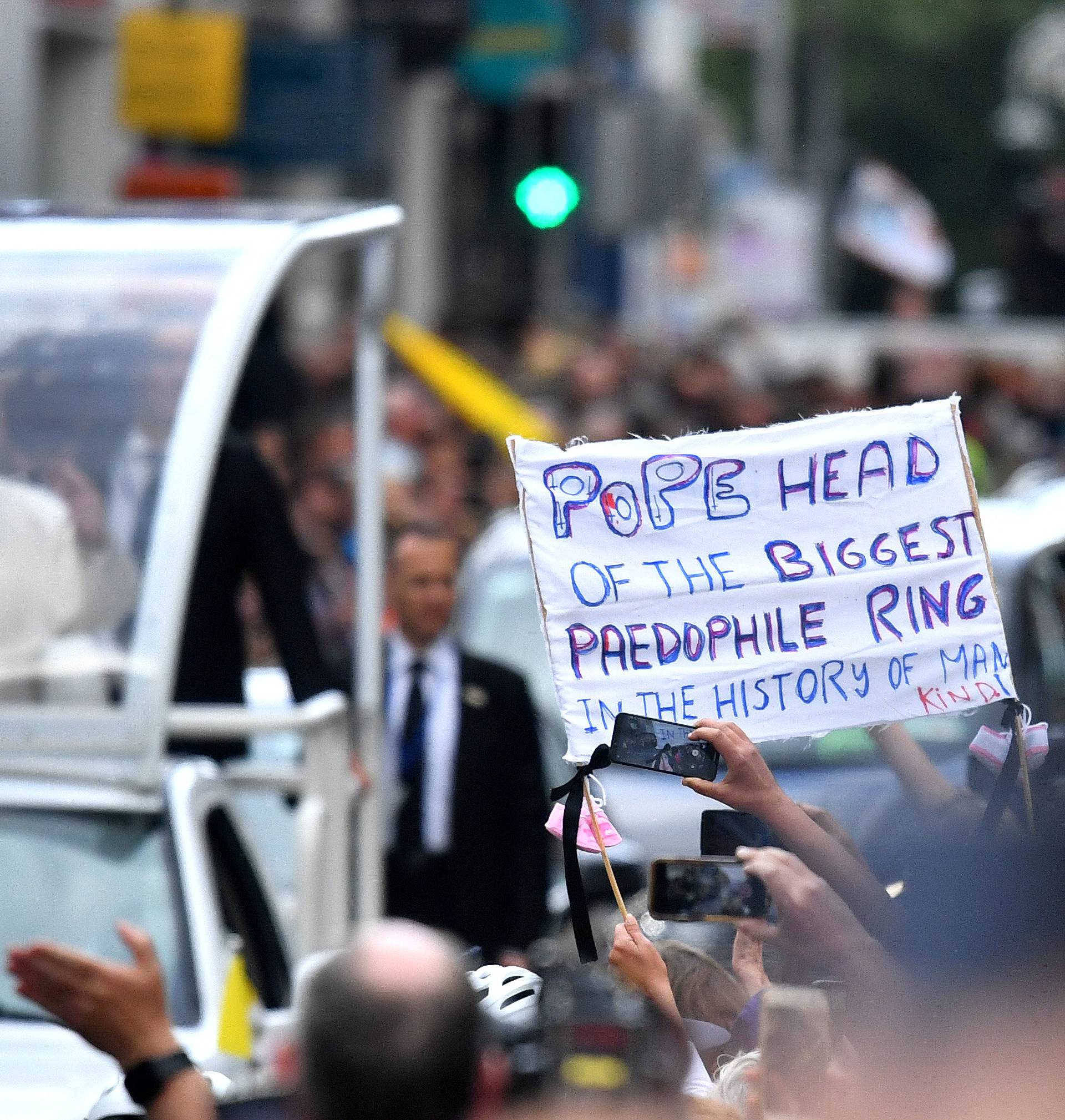 A protestor holds a banner as Pope Francis drives by during his visit in Dublin