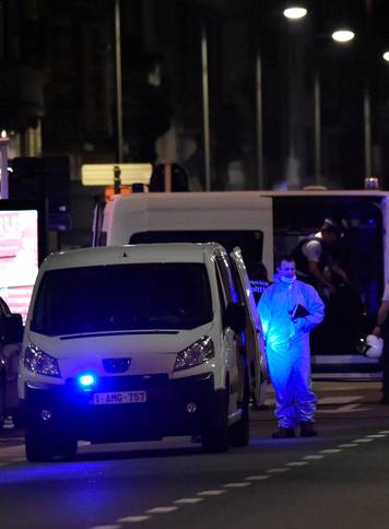 Policemen stand on the scene after Belgian soldiers shot a man who attacked them with a knife, in Brussels