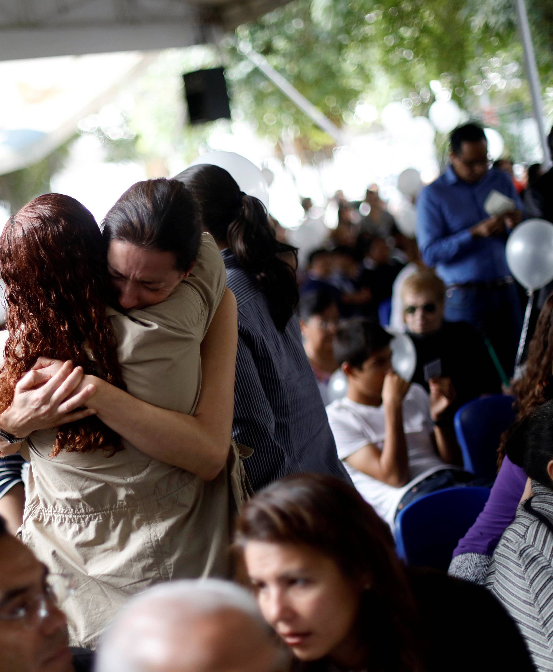 Family members and friends of children and grown-ups who died after their school collapsed in an earthquake, attend a mass, in Mexico City