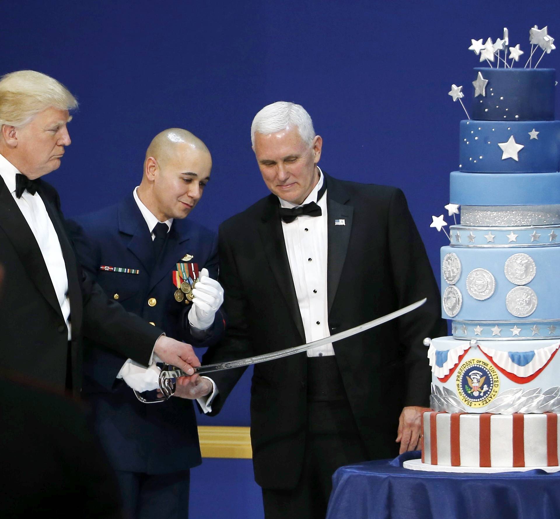 U.S. President Donald Trump and Vice President Mike Pence prepare to cut a cake with a sword at the "Salute to Our Armed Forces" inaugural ball during inauguration festivites in Washington