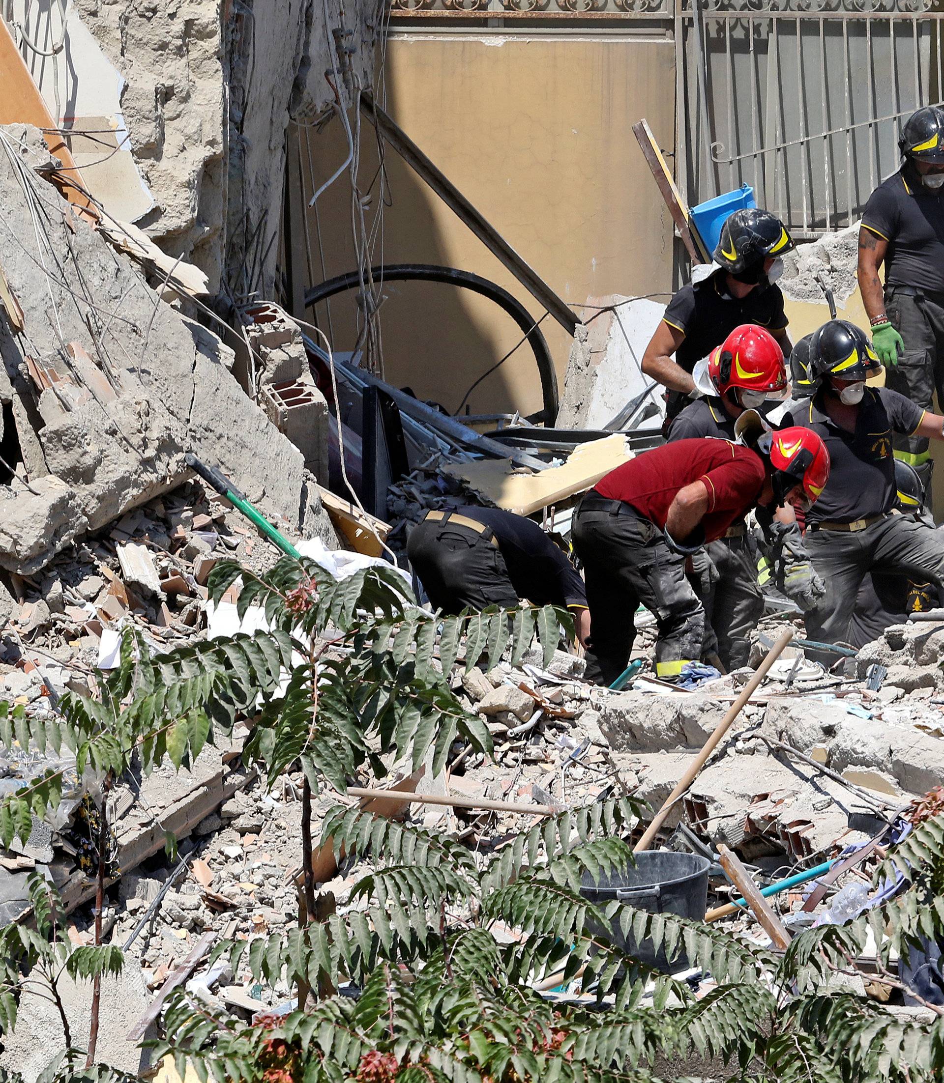 Firefighters work on the site of a collapsed building in Torre Annunziata