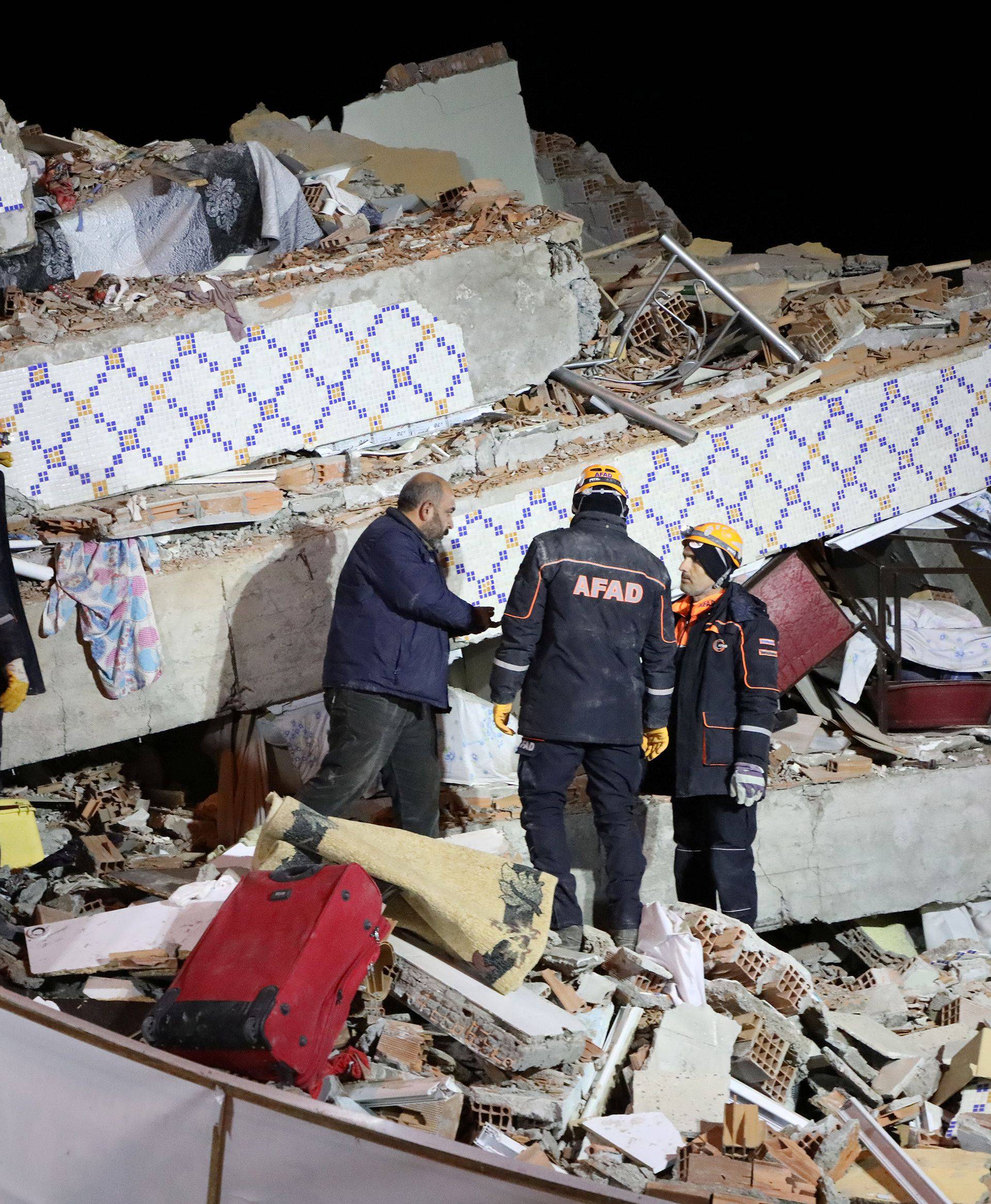 Rescue workers search on a collapsed building after an earthquake in Elazig