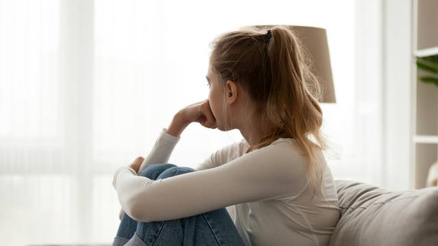 Side,View,Young,Woman,Looking,Away,At,Window,Sitting,On