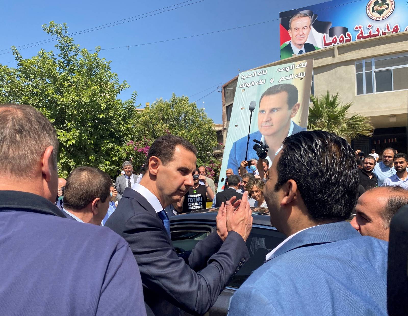 Syria's President Bashar al-Assad gestures as he leaves a polling station after casting his vote, during the country's presidential elections in Douma
