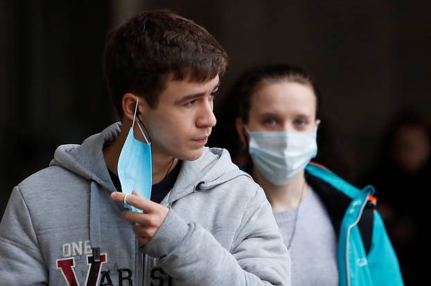 People wearing protective face masks walk in a street amid the outbreak of the coronavirus disease in Moscow
